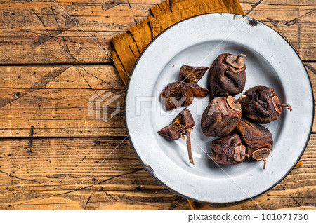 Natural Sun Dried persimmon fruit on a plate. Wooden background. Top view. Copy space Natural Sun Dried persimmon fruit on a plate. Wooden background. Top view. Copy space 101071730