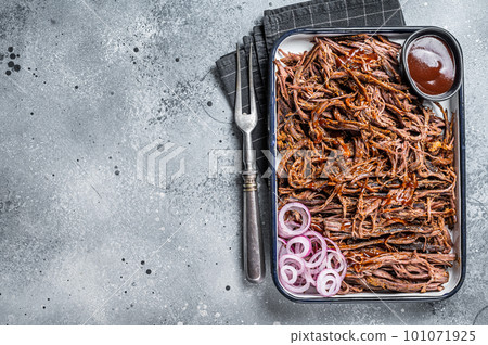 Pulled beef meat with hot chili sauce in baking dish. Gray background. Top view. Copy space Pulled beef meat with hot chili sauce in baking dish. Gray background. Top view. Copy space 101071925