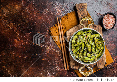 Roasted green Edamame Soy Beans with sea salt and sesame seeds in a skillet. Dark background. Top view. Copy space Roasted green Edamame Soy Beans with sea salt and sesame seeds in a skillet. Dark background. Top view. Copy space 101071952