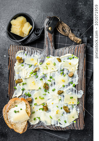 Butter board with herbs, lemon zest, capers, parmesan cheese and sea salt, Butterboard. Black background. Top view 101071959