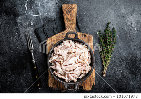 Sliced Pieces of chicken meat in a skillet, pulled chicken. Black background. Top view 101071978