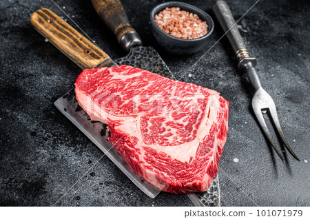 Butcher table with wagyu Rib Eye steak, raw beef meat. Black background. Top view 101071979