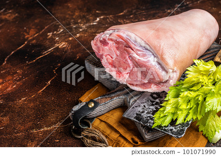 Fresh Raw pork shank knuckle on a butcher board with herbs for cooking. Dark background. Top view. Copy space Fresh Raw pork shank knuckle on a butcher board with herbs for cooking. Dark background. Top view. Copy space 101071990
