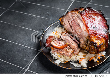 Roast Pork Ham Hock, knuckle with Sauerkraut on a plate. Black background. Top view. Copy space Roast Pork Ham Hock, knuckle with Sauerkraut on a plate. Black background. Top view. Copy space 101072005