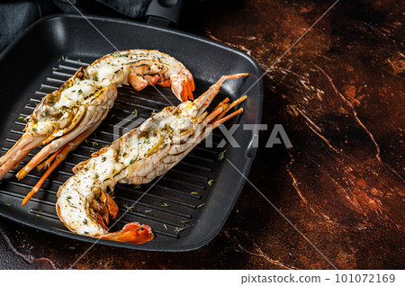 Delicious grilled and sliced Spiny lobster or sea crayfish. Dark background. Top view. Copy space Delicious grilled and sliced Spiny lobster or sea crayfish. Dark background. Top view. Copy space 101072169