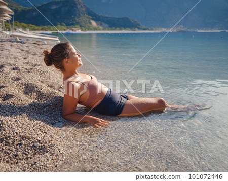 Cheerful woman enjoying the beach 101072446