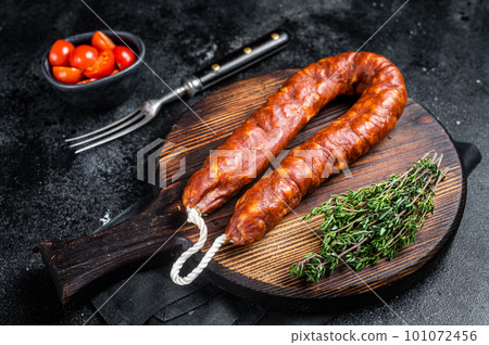 Traditional spanish Chorizo sausage, dry cured pork meat. Black background. Top view 101072456