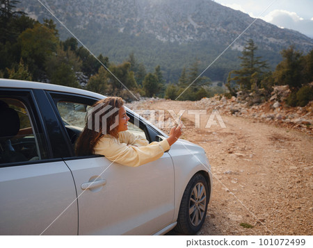 Woman on road trip traveling by rental car Woman on road trip traveling by rental car 101072499