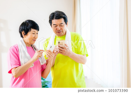 Senior couple exercising Smartphone Senior couple exercising Smartphone 101073390