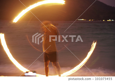 man performing fire show dancing with flame at night man performing fire show dancing with flame at night 101073455