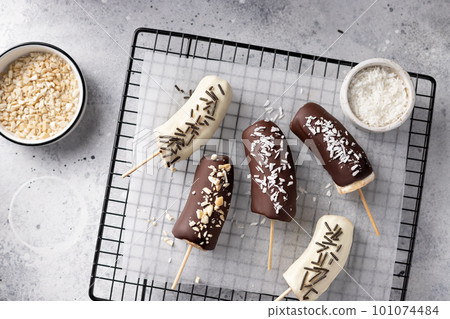 frozen bananas in dark and white chocolate 101074484