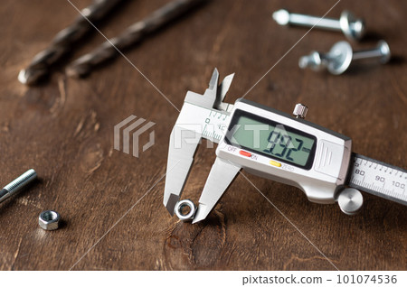 Digital caliper on wooden background Digital caliper on wooden background 101074536