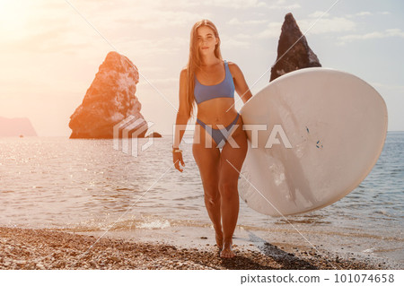 Woman sea sup. Close up portrait of happy young caucasian woman with long hair looking at camera and smiling. Cute woman portrait in bikini posing on sup board in the sea Woman sea sup. Close up portrait of happy young caucasian woman with long hair looking at camera and smiling. Cute woman portrait in bikini posing on sup board in the sea 101074658