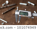 Modern electronic caliper on blurred wooden background 101074949