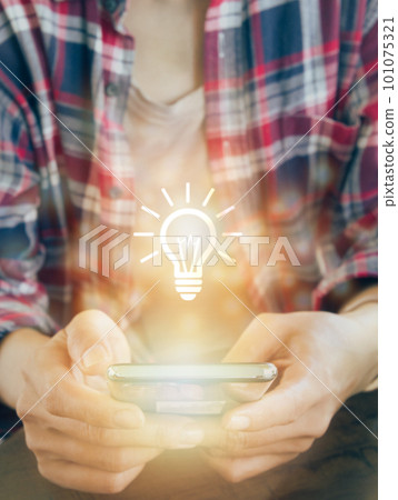 Glowing light bulb icon on smartphone. to get Business , earning money, knowledge, learning, leadership, idea, innovation and creativity concept. 101075321
