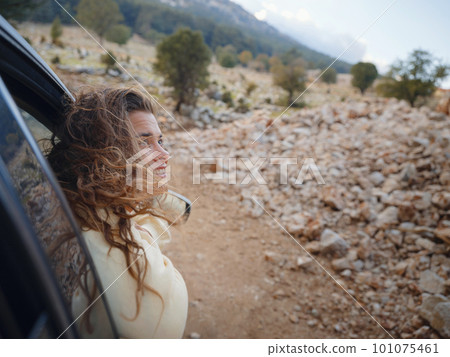 Woman on road trip traveling by rental car 101075461