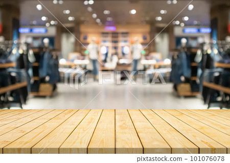 Empty wood table top with blur clothing boutique display interior shopping mall background 101076078