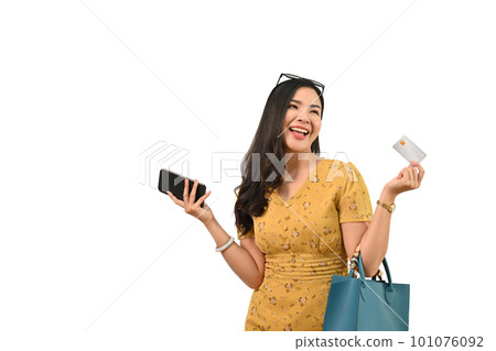 Portrait of cheerful stylish woman holding credit card and mobile phone posing on white background Portrait of cheerful stylish woman holding credit card and mobile phone posing on white background 101076092