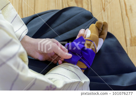A woman's hand inserting a kake (yugake) A woman's hand inserting a kake (yugake) 101076277