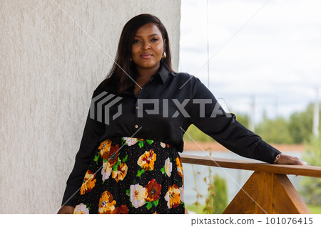 Beautiful african american woman enjoying evening on village and nature on terrace of country house. Diversity and inclusion and cottagecore concept 101076415