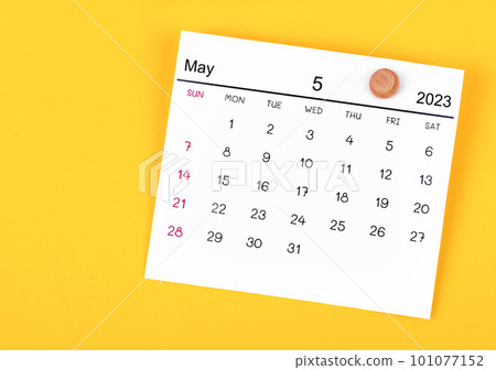 The May 2023 calendar and wooden push pin on yellow background. The May 2023 calendar and wooden push pin on yellow background. 101077152