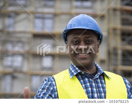 Portrait of a smiling Indian civil engineer or factory worker wearing a blue helmet and looking at camera Portrait of a smiling Indian civil engineer or factory worker wearing a blue helmet and looking at camera 101078225