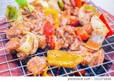 Barbecue skewers meat with vegetables on grill close up Barbecue skewers meat with vegetables on grill close up 101078866