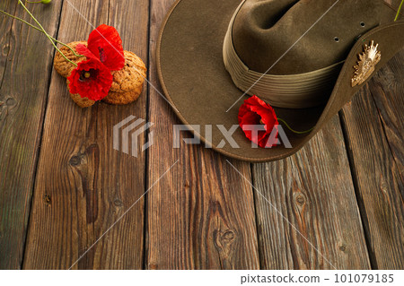 Australian Anzac Day. Australian army slouch hat red poppy and traditional Anzac biscuits on wooden background. Australian Anzac Day. Australian army slouch hat red poppy and traditional Anzac biscuits on wooden background. 101079185