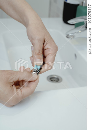 man cutting his fingernails 101079367