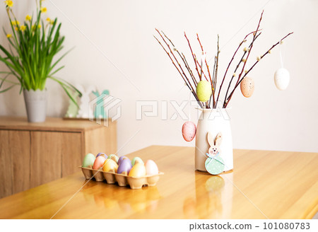 Easter decoration with a bouquet of the willow branches with colored eggs, flowers and rabbits. Easter decoration with a bouquet of the willow branches with colored eggs, flowers and rabbits. 101080783