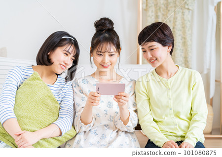 A young woman watching a video on her smartphone A young woman watching a video on her smartphone 101080875