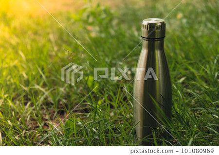 Water bottle. Reusable steel thermo water bottle on green grass. Sustainable lifestyle. Plastic free zero waste free living. Go green Environment protection 101080969