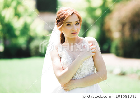 Beautiful bride posing in wedding dress outdoors Beautiful bride posing in wedding dress outdoors 101081385