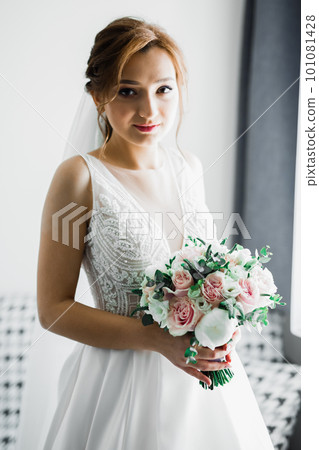Portrait of stunning bride with long hair posing with great bouquet 101081428