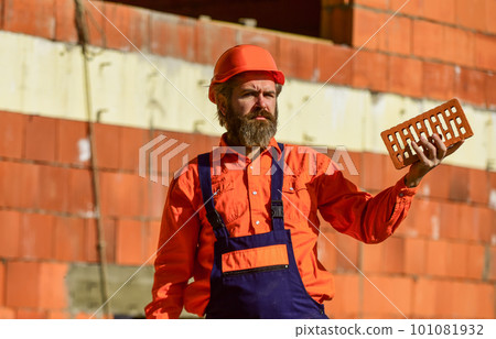 brickwork. Man takes brick from the pile. Male construction worker holding brick. Repairman guy hard build up new layer level. build your own future. bearded man hold brick 101081932