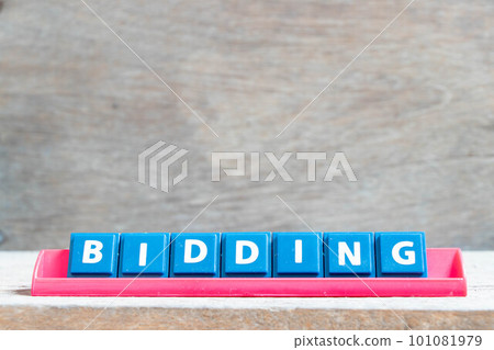 Tile alphabet letter with word bidding in red color rack on wood background 101081979