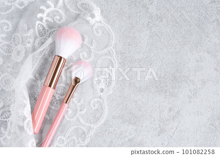Cute pink makeup brushes wrapped in white lace 101082258