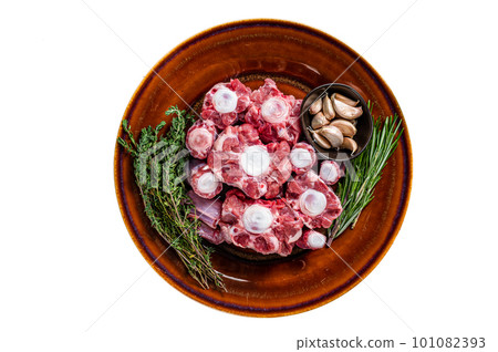 Fresh uncooked beef Oxtail cut Meat on rustic plate with herbs. Isolated on white background. Fresh uncooked beef Oxtail cut Meat on rustic plate with herbs. Isolated on white background. 101082393
