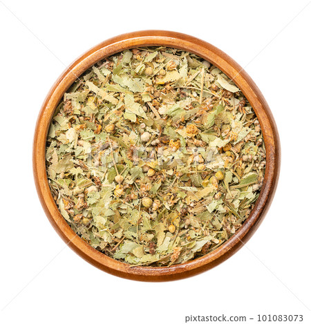 Dried linden flowers, in a wooden bowl. Flowers, fruits and bract leaves of the large-leaved linden or lime tree, Tilia platyphyllos. Used for herbal tea and topically in traditional medicine. Photo. 101083073