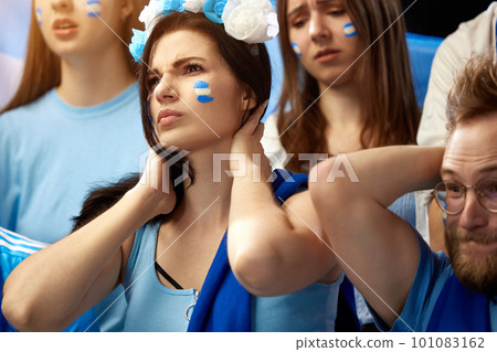 Young people watching football match at stadium. Losing goal, sad emotions. Cheering up favourite football, soccer team of greece Young people watching football match at stadium. Losing goal, sad emotions. Cheering up favourite football, soccer team of greece 101083162