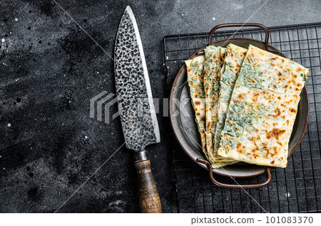 Gozleme Turkish flatbread with greens and cheese. Black background. Top view. Copy space 101083370