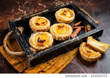 Belem cakes or Pasteis de Belem, Portuguese pastel de Nata Custard Tarts. Dark background. Top view 101083372