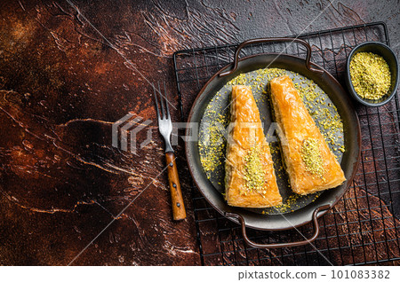 Turkish Havuc Dilim Baklava with pistachio. Dark background. Top view. Copy space 101083382