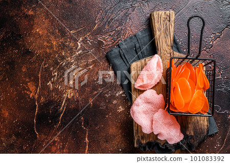 Cooking raw kerupuk or prawn shrimp crackers, chips. Asian fastfood. Dark background. Top view. Copy space Cooking raw kerupuk or prawn shrimp crackers, chips. Asian fastfood. Dark background. Top view. Copy space 101083392