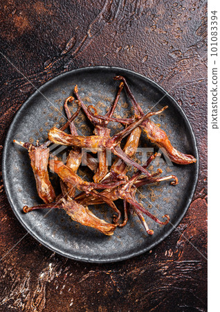 Spicy Dip fried duck tongue. Dark background. Top view Spicy Dip fried duck tongue. Dark background. Top view 101083394