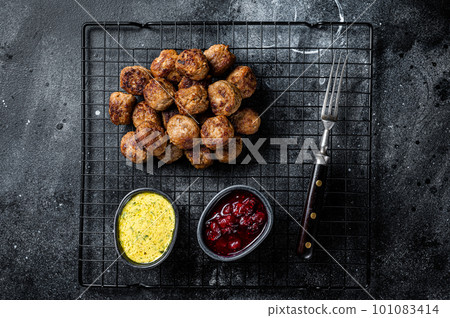 Swedish meatballs with lingonberries and gravy sauce. Black background. Top view 101083414
