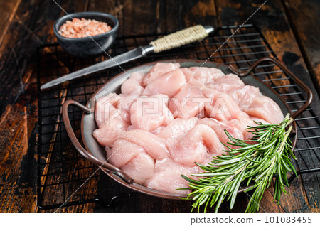 Diced raw chicken breast fillets with herbs, fowl meat. Wooden background. Top view 101083455