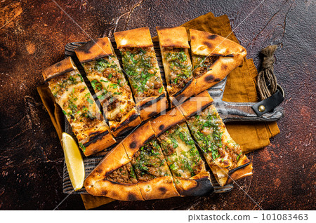 Traditional Turkish baked pide, Middle Eastern snack. Turkish pizza. Dark background. Top view 101083463