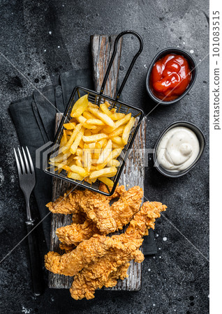 Chicken breast strips with French Fries and Ketchup. Black background. Top view 101083515