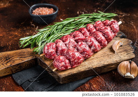 Raw traditional shish kebab Skewers with beef meat ans spices. Dark background. Top view 101083526